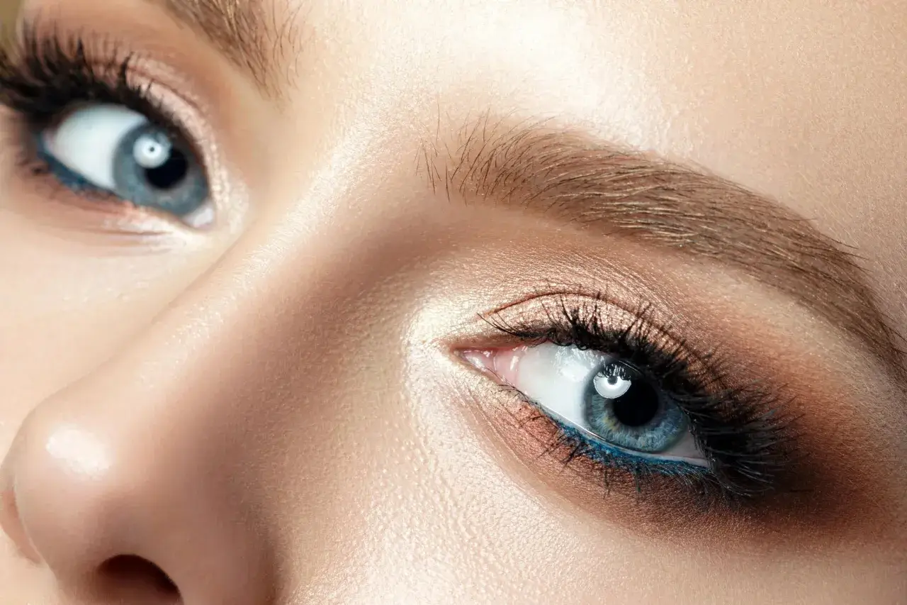 Nahaufnahme eines blauen Auges mit braunem Lidschatten und blauer Eyeliner-Linie. Perfekt für die Frage: welche haarfarbe bei blauen augen.