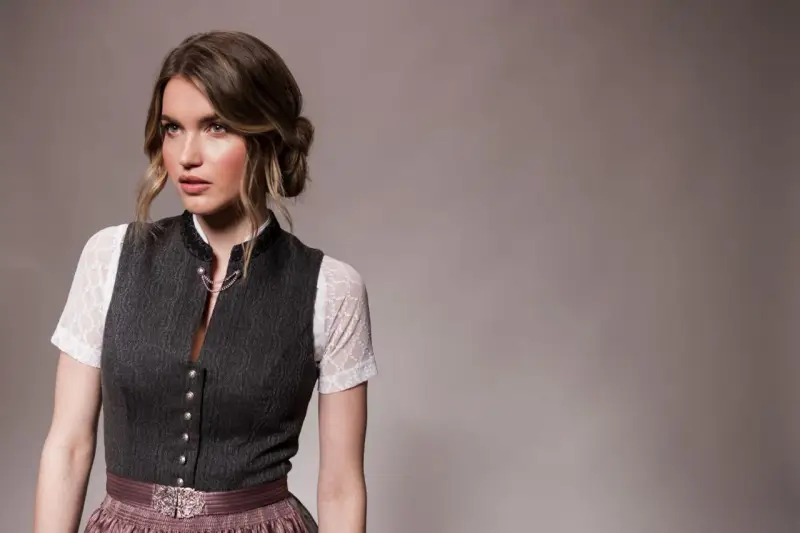 Eine Frau mit einer eleganten Dirndl-Frisur für kurze Haare trägt ein traditionelles Dirndl.